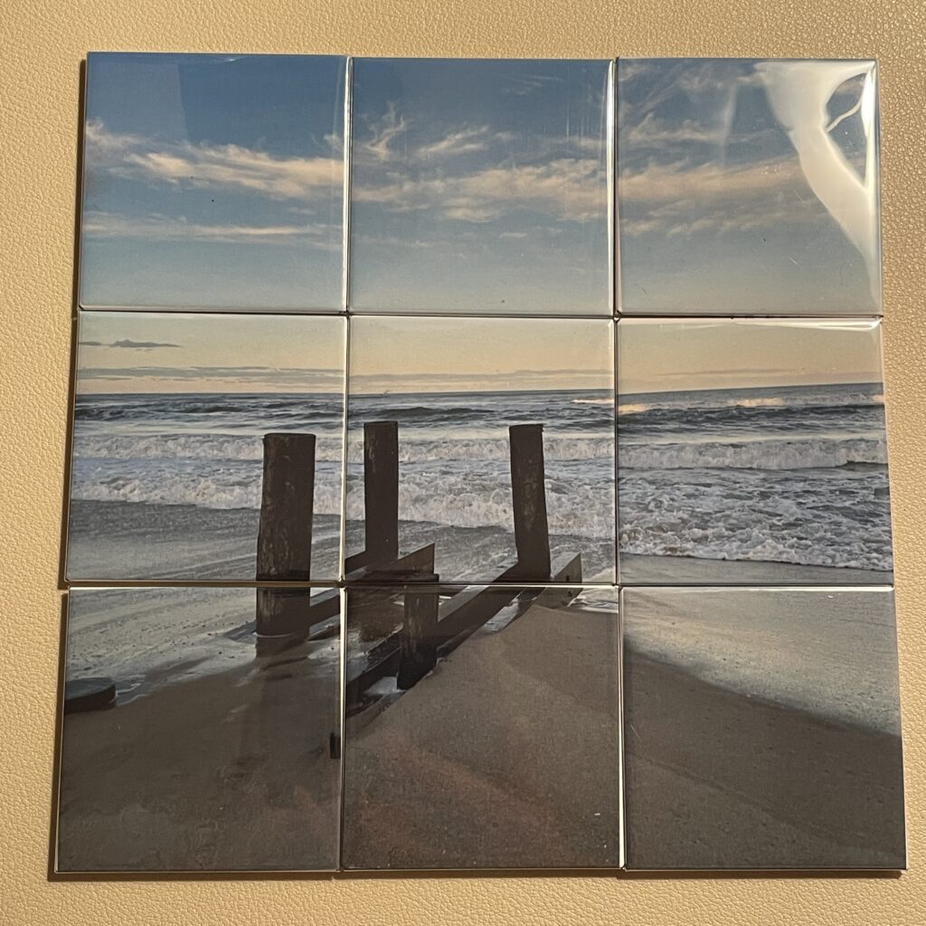 Nine photo tiles depict a serene beach scene with wooden posts and gentle waves under a cloudy sky, evoking tranquility and nature's beauty.